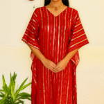 a flowing, red caftan (or kaftan) featuring vertical gold metallic stripes and a subtle V-neckline.